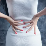woman in white sleeveless dress -performing a gentle thoracic spine stretch to relieve back ache when breathing deeply, sitting upright with proper posture.